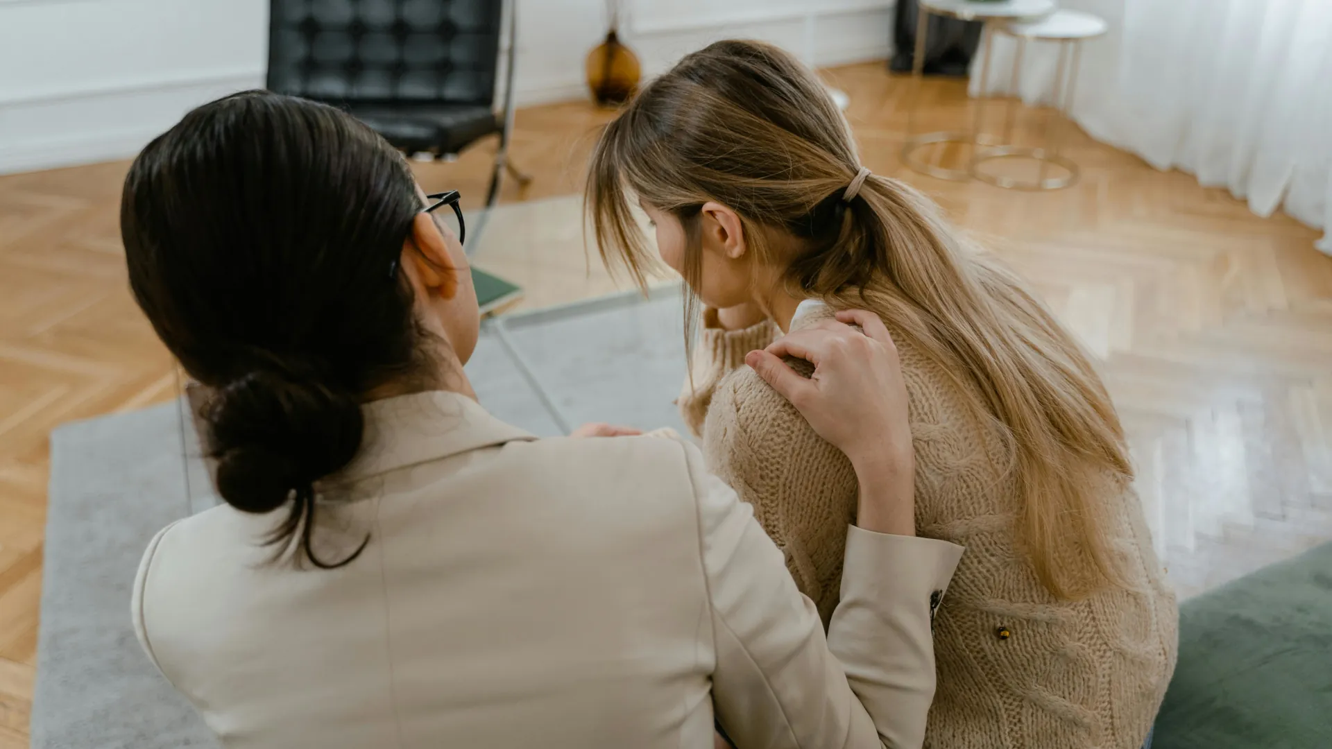 A young woman is being comforted by a counsellor using EMDR practices.