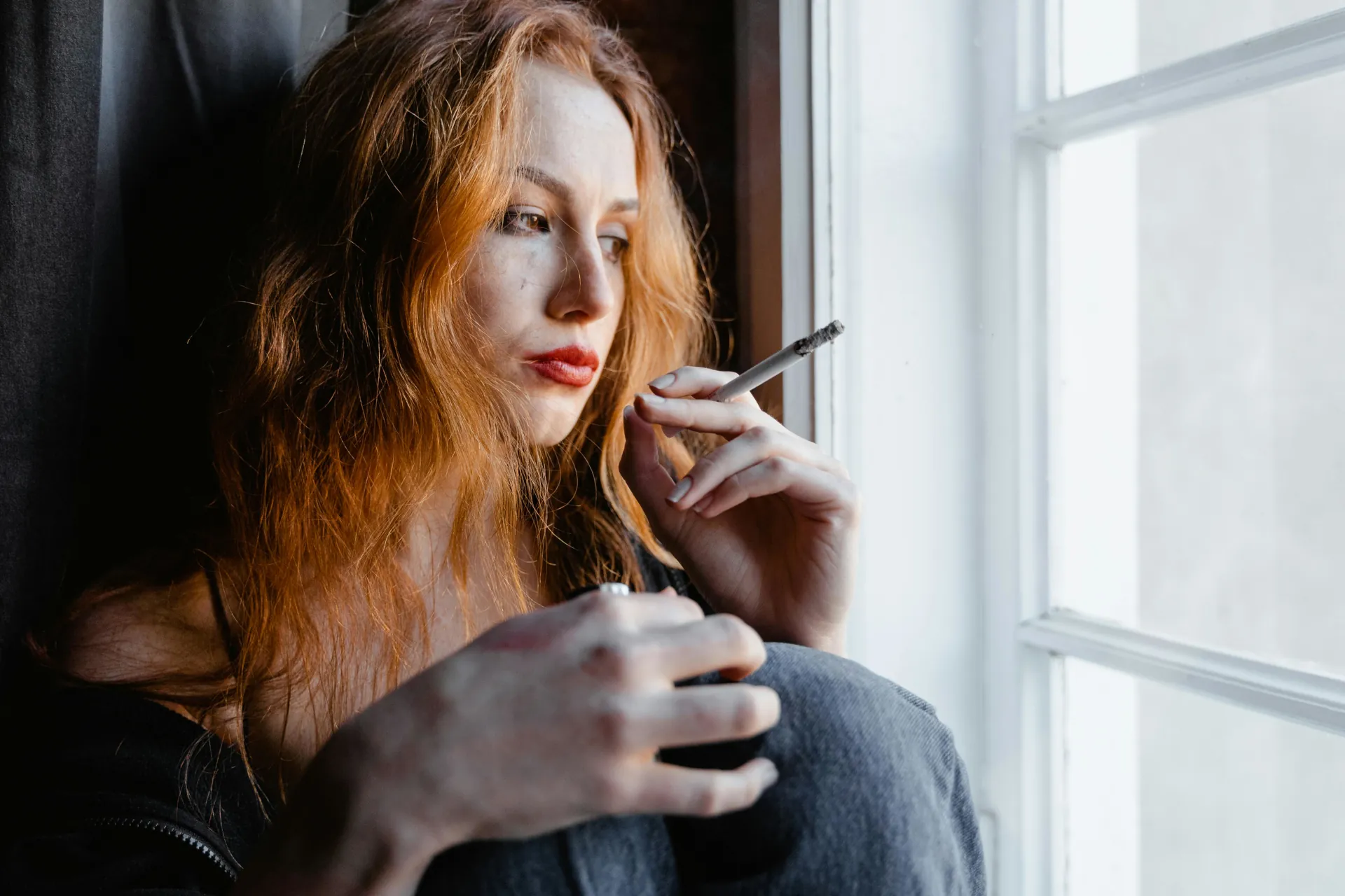 Young female smoking a lit cigarette.